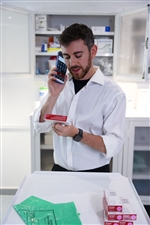 hc50-apotheker-am-telefon-schaut-auf-arzneimitteletikett